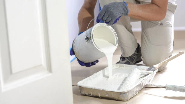 artisan préparant de la peinture pour une application extérieure